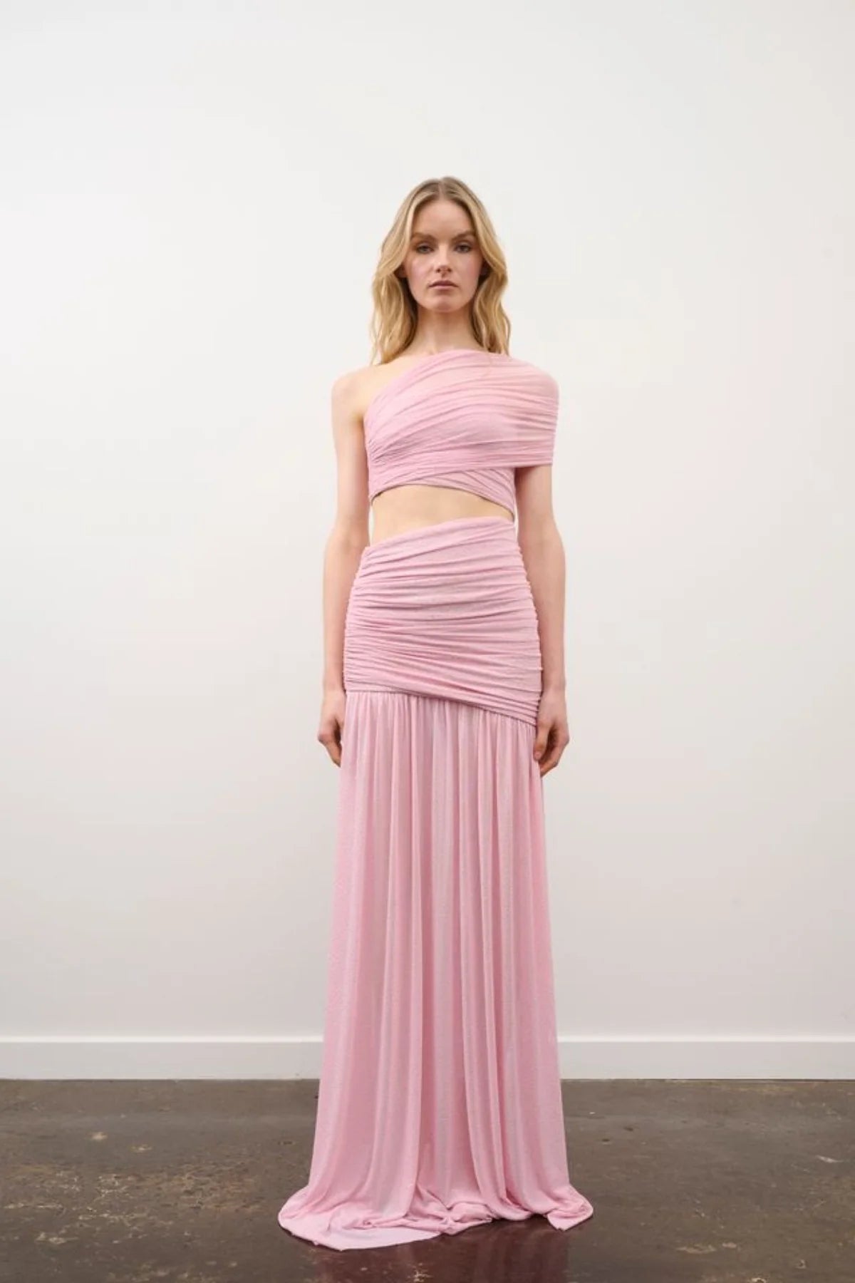 Woman wearing a pink two-piece dress against a white background
