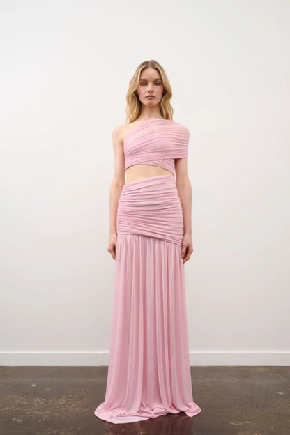 Woman wearing a pink two-piece dress against a white background