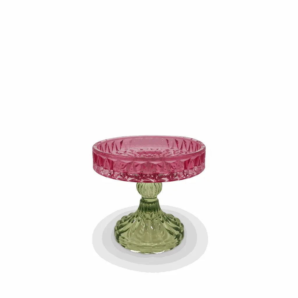 Decorative glass bowl with pink top and green base on a white background