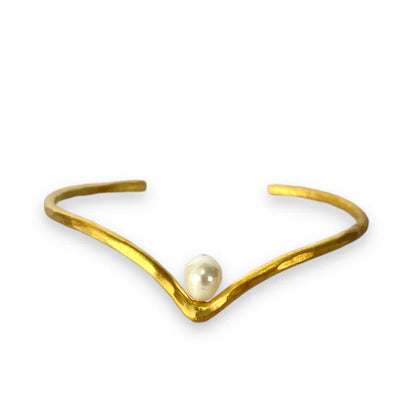 Gold bracelet with a pearl on a white background