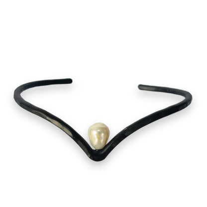 Black necklace with a pearl pendant on a white background